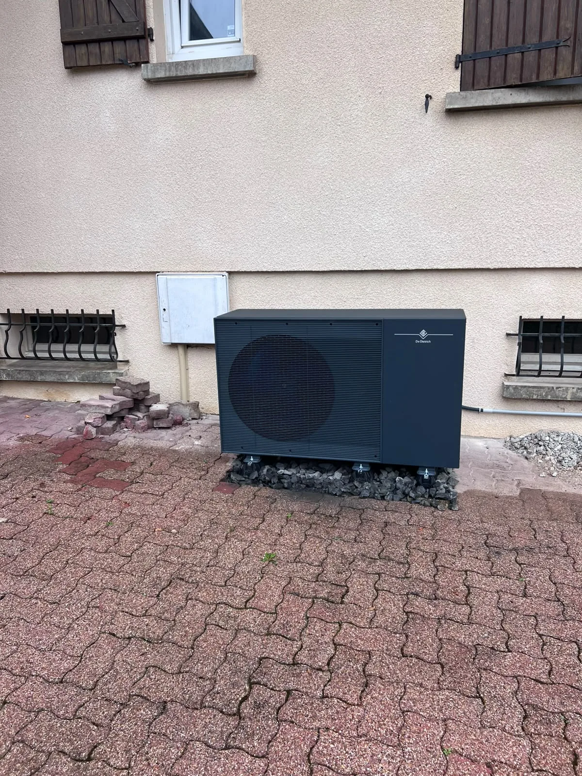 Groupe extérieur de la pompe à chaleur air-eau De Dietrich Alezio M 12 kW posé sur plots devant la maison de notre client à Lantenne-Vertière (Doubs), 01 Octobre 2026.