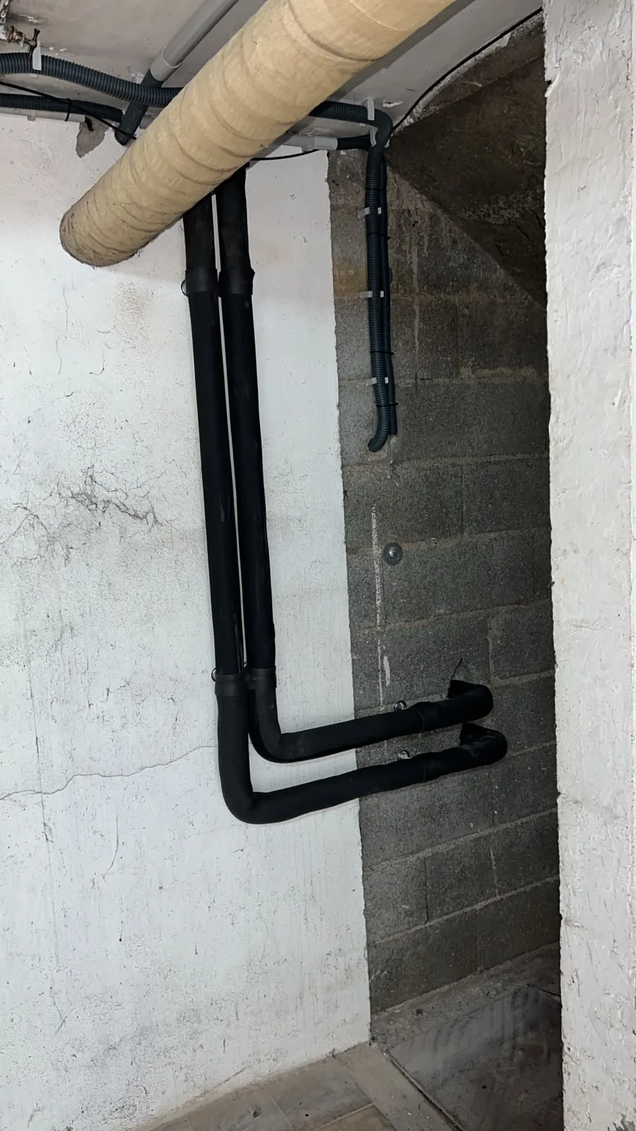 Liaisons hydrauliques isolées le long du mur du sous-sol, entre le groupe extérieur et le local technique, chez notre client à Lantenne-Vertière (Doubs).