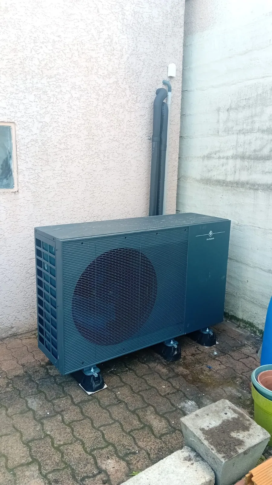 Groupe extérieur de la pompe à chaleur air-eau De Dietrich Alezio M Control R290 de 12 kW posé sur plots chez notre client à Chalon-sur-Saône (Saône-et-Loire).